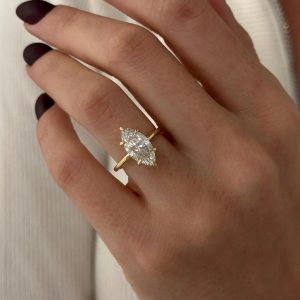 Marquise three stone engagement ring with pavé gallery beneath the stones