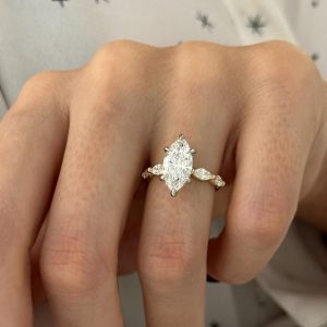 Marquise diamond engagement ring with prong set center and accent stones