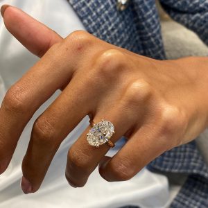 Oval solitaire engagement ring with four prongs and plain rounded band