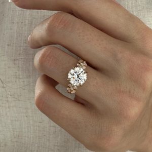 Round diamond engagement ring with hidden halo and organic side stones
