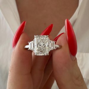 Radiant cut three-stone diamond engagement ring with baguette side stones on a polished band