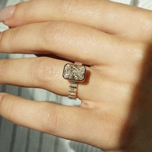 Radiant bezel engagement ring with channel-set baguette diamond accents