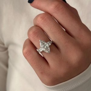 Four-stone designer ring with marquise and pear-shaped stones set in a floral motif