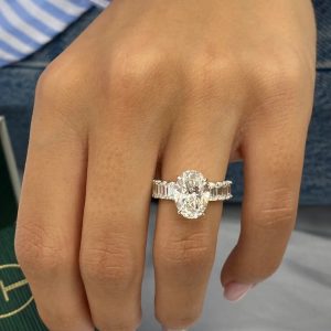 Oval diamond ring with four-prong setting and channel baguette side stones