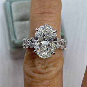 Oval diamond engagement ring with four-prong basket setting and full eternity round diamond band