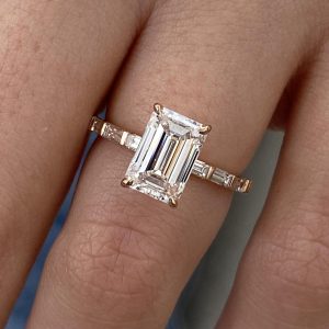 Emerald cut engagement ring with baguette channel-set side stones and a straight shank