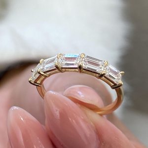 Five stone emerald-cut diamond shared prong ring with polished half band