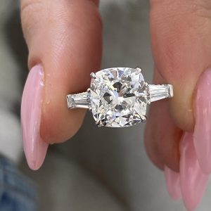 Cushion cut three stone engagement ring with tapered baguette diamonds