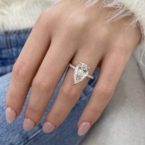 Pear-shaped hidden halo pavé engagement ring with elevated basket and open gallery