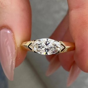 East-west marquise diamond solitaire ring with bezel setting and tapered band