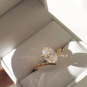 Curved band ring with a pear-shaped diamond in a five-prong solitaire setting