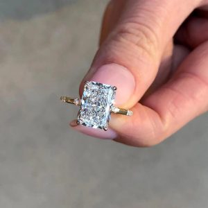 Radiant cut engagement ring with hidden halo and pavé-set band