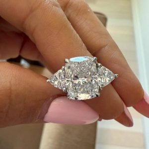Cushion cut three stone engagement ring with polished plain band