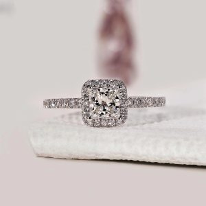 Rectangular halo engagement ring with pavé shank and basket setting