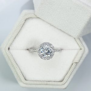 Elegant round halo pavé diamond engagement ring with four-prong setting