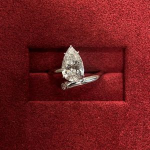 Pear solitaire engagement ring paired with a chevron contour band