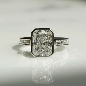 Radiant cut diamond bezel engagement ring with channel baguette side stones