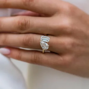 Bypass ring with pear and emerald-cut stones on an open plain band