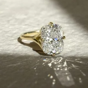 Elongated cushion-cut solitaire engagement ring with four-prong setting on a plain tapered band